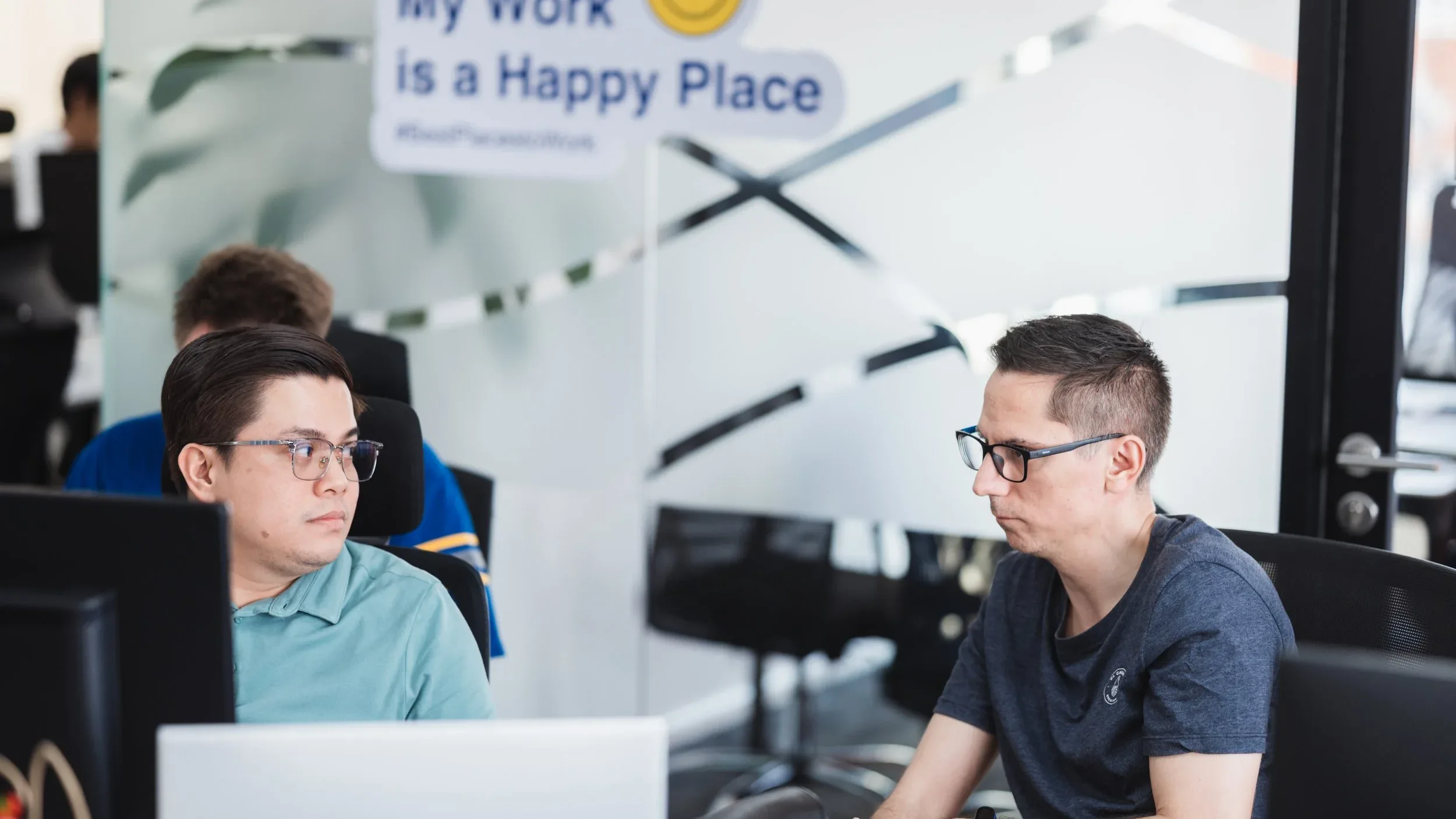 พนักงานในสำนักงาน Best Places to Work™ กับข้อความ My Work is a Happy Place สะท้อนวัฒนธรรมองค์กรที่สร้างความสุขในการทำงานปี 2026